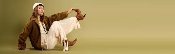 Молода жінка демонструє свій унікальний стиль в розслабленому позі з нейтральним фоном. — стокове фото