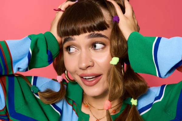 Весела молода жінка з веселою зачіскою яскраво посміхається, грайливо тримаючи волосся. — стокове фото