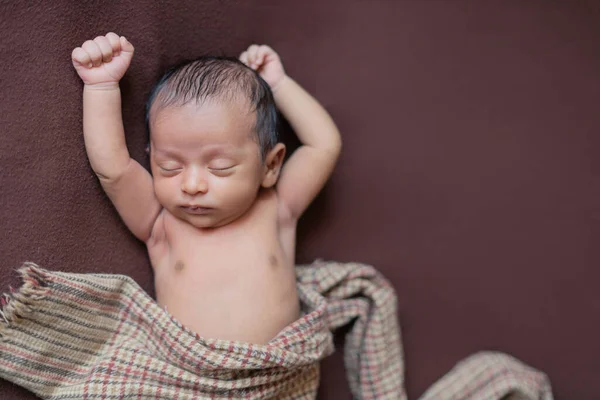 Nyfødt Gutt Som Sover Fredelig Brunt Teppe Med Begge Hender – stockfoto