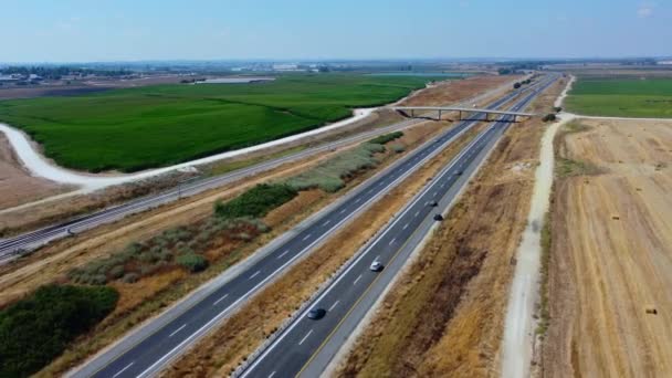 Movimiento de coches en la carretera, la carretera a lo largo de los campos. Imágenes de alta calidad de 4k. Vista aérea — Vídeo de stock