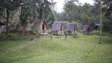 Doğal orman parkında geleneksel ahşap kulübeler çevre dostu konaklama ve açık hava rahatlığı sunar.