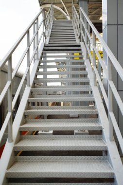 Modern bir tren istasyonundaki metal merdiven, endüstriyel mimariyi ve kentsel ulaşım tasarımını gösteriyor