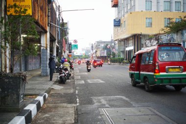 Bandung Endonezya - 21 Ekim 2025 Sabahları toplu taşıma ve motosikletli bir şehir manzarası, Endonezya 'daki günlük şehir yaşamını gösteriyor.