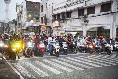 Bandung Endonezya - 21 Ekim 2025 Yoğun şehir trafiği kırmızı ışıkta bekleyen motosikletliler, Endonezya 'nın büyük kentlerindeki insanların günlük yaşamlarını resmediyor..