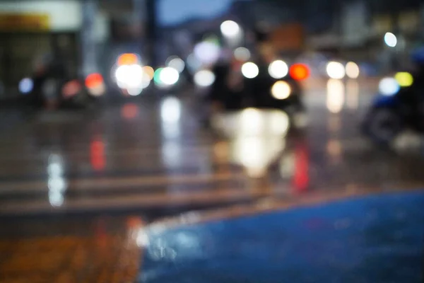 Yağmurdan sonra ıslak bir sokakta gece şehir trafiğinin soyut sahte ışıkları renkli ve sanatsal bir zemin oluşturur..