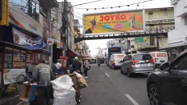 Bandung Endonezya - 21 Ekim 2025 Bandung, Endonezya şehir merkezinde sakin bir sokak manzarası, öğleden sonra binaları ve araçları gösteriyor.