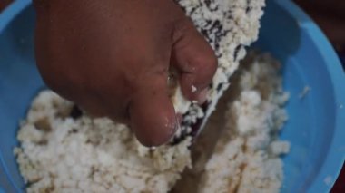 Geleneksel rendeleyici kullanarak mandalinayı elle rendeleyen birinin yakın çekimi, otantik Endonezya yemek hazırlığını gösterir