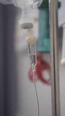 Hastane ortamında sürekli sıvı damlayan bir serum odasının yakın çekimi..