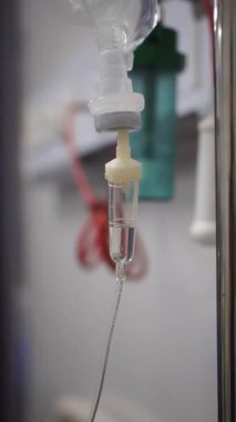 Hastane ortamında sürekli sıvı damlayan bir serum odasının yakın çekimi..