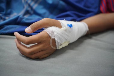 Sağlık sigortası konsepti, tıbbi bakım sırasında hastanın eline takılan serumu gösteriyor.