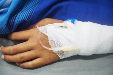 Sağlık sigortası konsepti, tıbbi bakım sırasında hastanın eline takılan serumu gösteriyor.