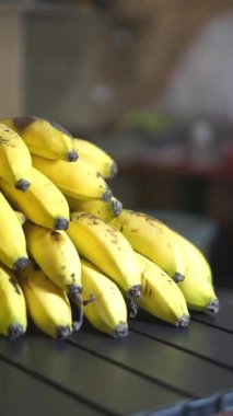 Bir yığın sarı Ambon muzunu siyah bir masada düzgünce yerleştirin.