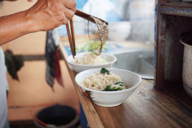 Geleneksel tavuklu şehriye hazırlama çeşnisi doğrudan kaseye ekleniyor..