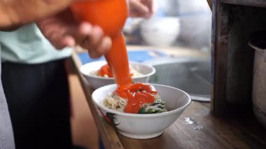 Geleneksel tavuklu şehriye hazırlama çeşnisi doğrudan kaseye ekleniyor..