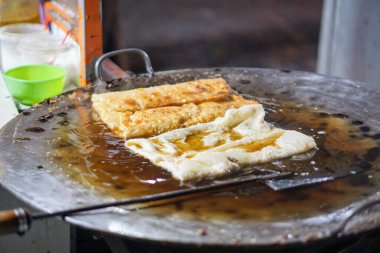 Yumurta martabak, geleneksel Endonezya sokak yemeği olarak sıcak yağla dolu büyük bir tavada kızartılır..