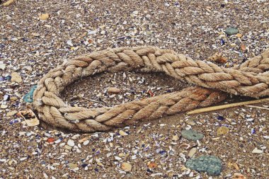 Kumsalda eski bir ip. Eski, kirli ve yıpranmış bir ipe yakın çekim.