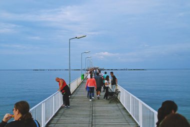 Köstence / Romanya; 07 / 05 / 2018. İnsanlar Constanta 'daki Mamaia Sahili' nde geziniyorlar. Uzun, ahşap bir iskele. Orada yürüyebilirsin ve mükemmel bir sahil manzarası var..
