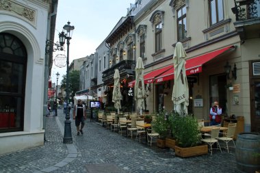 Bükreş, Romanya; 07 07 07 2018: Covaci Caddesi ve Bükreş 'teki City Grill Covaci restoranı. Bükreş 'in tarihi merkezinde gün batımında restoran terasları hazırlandı.