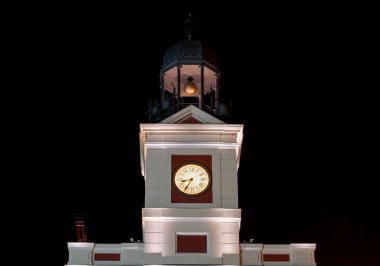 Puerta del Sol Meydanı 'ndaki ana binanın kulesindeki saat. Madrid, İspanya 'nın şu anki başkanlığını yürüten postanenin sarayında geceleri elleri aydınlanıyordu..