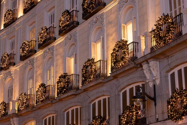 Facade of a building decorated with Christmas lights at night. A nice old building on the Puerta del Sol square in Madrid, Spain.