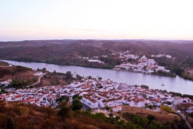 Sanlucar de Guadiana (İspanya) ve Alcoutim 'de (Portekiz) günbatımı. Bu iki kasaba arasında geçen Guadiana Nehri iki ülke arasındaki sınırı işaret ediyor. Fotoğraf İspanya 'dan çekildi..