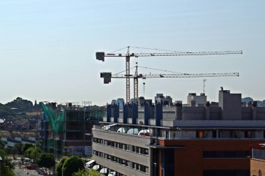 Madrid, İspanya; 08 / 25 / 2018. Madrid 'in Montecarmelo bölgesinde bir builiding inşaatı üzerinde çalışan kule vinçleri.