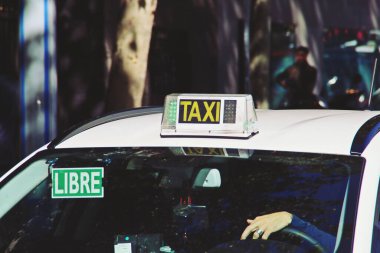 Madrid, İspanya 'da merkez bir caddede taksi şoförü bekliyor. Yeşil ışığı ve ücretsiz tabelası olan taksi şoförü (İspanyolca: libre) yolcuları alabileceğini belirtiyor.