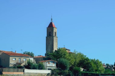 Bell tower of the Church of Our Lady of the Rosary of the Alcolea del Pinar town. Bell tower that stands out above the rest of the roofs of the houses in the town. Soria, Spain. clipart