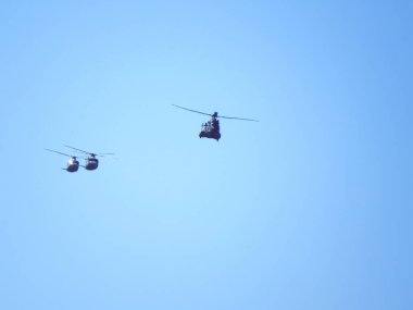 Helikopterler açık bir gökyüzünde düzenle uçuyorlar. İspanyol Hava Kuvvetleri 'nin üç helikopterinin silueti..