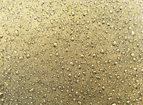 Raindrops on the cloth of an umbrella. Close-up of the small pearl-like drops.