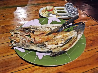 Tayland 'ın Koh Tao kentindeki bir restoranda aynı közde, sularında pişmiş patatesle birlikte ızgara balık..