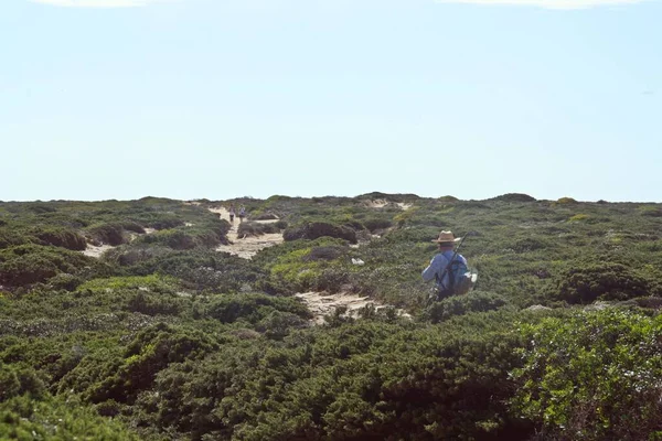 Elder fisherman (and hikers) going to the top of the Cliff in the Cape of San Vicente, Sagres, Algarve, Portugal.