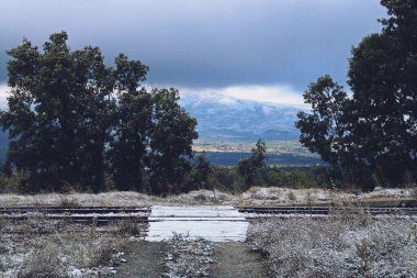 Gascones-Buitrago istasyonundaki eski tren yolu üzerinde tahta patika ve kar taneleri var. İspanya 'nın Madrid kentindeki bu unutulmuş istasyonda ilk sonbahar kar yağışından sonra kırsal alan.