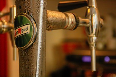 Madrid, İspanya; 02 07 2016. Bir İspanyol barında bira servisi için San Miguel bira şirketinin fıçı birası. Metal üzerinde yoğunlaştırılmış su damlacıkları olan yakın çekim.