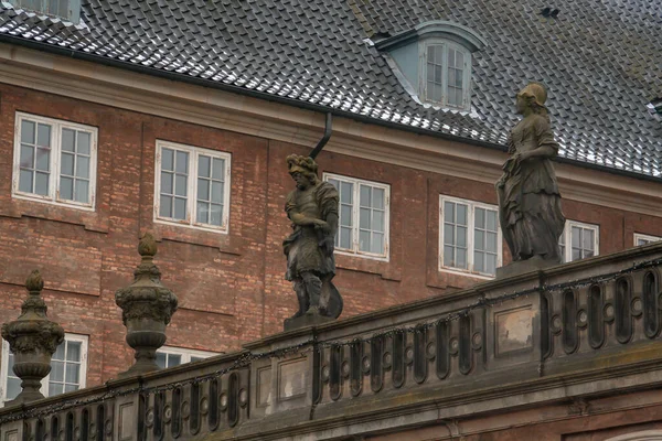 The National Museum (Translation: National Museet) of Denmark in Copenhagen, its capital. Decorative and weathered statues on the upper part of the facade.