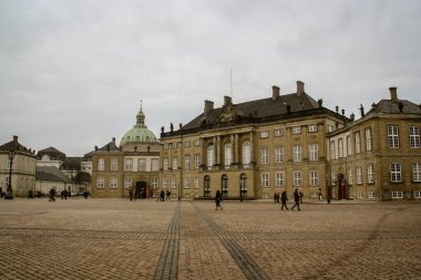 Amalienborg Sarayı, Danimarka kraliyet ailesinin evi ve Kopenhag 'daki Frederik' in kilisesinin kubbesi. Kışın bulutlu bir gününde bu ünlü yeri ziyaret eden turistler.