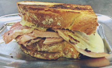 Yarım somun ekmekle yapılmış lezzetli bir jambonlu ve peynirli sandviç. Madrid, İspanya 'da sıcak bir barda yemek için lezzetli ve besleyici bir atıştırmalık..