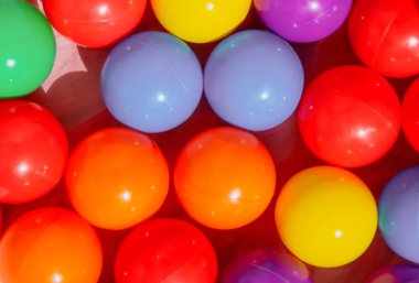 Renkli plastik toplar havuzu (renkli arka plan). Oyun parkında oynamak için dizilmiş toplar.