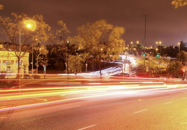 Madrid, İspanya. 10: 30 2018. Madrid 'deki Montecarmelo Bulvarı ve Tres Olivos Köprüsü' nde gece trafiği. Yağmurlu bir gecede, araba ışıklarından hafif patikalar.