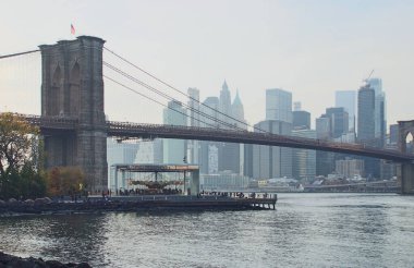 Akşam karanlığında Manhattan ve East River şehir manzarası. Brooklyn Köprüsü, Jane 'in Atlıkarınca' sı ve ana cadde parkının çimlerinden Manhattan. 2019 sonbaharı. New York City, ABD.