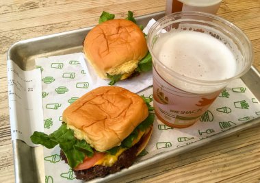 New York, ABD. 12 Kasım 2019. Restoranda bir tepsi hamburger ve bira. Shake Shack 'in üst batı yakasında Amerikan Doğa Tarihi Müzesi' nin yanında servis ediliyor..