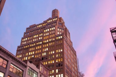 New York City 'nin günbatımı gökdelenleri, ABD. 246 Beşinci Cadde 'deki gökdelenler batan güneşin son ışığıyla pembe ve maviye boyanmış. Sonbahar 2019.