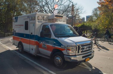 New York, ABD. 13 Kasım 2019. New York 'ta güneşli bir sonbahar gününde acil tıbbi araç hizmet veriyor. New York-Presbiteryen Hastanesi ambulansı Central Park 'ın yanında sürüyor..