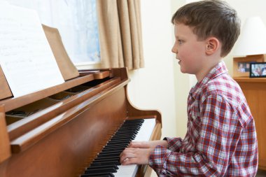 Genç çocuk evde piyano