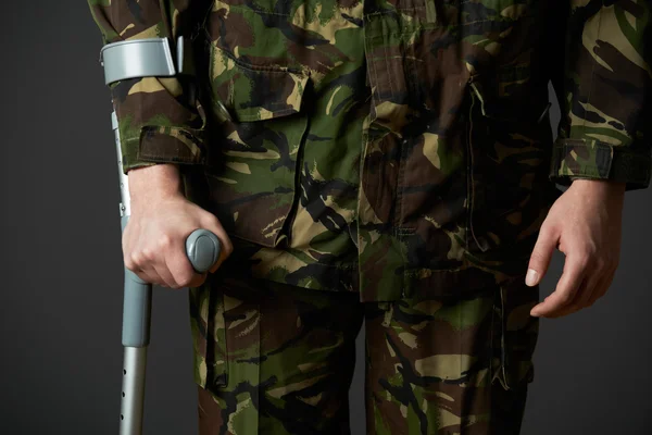 Studioaufnahme eines verwundeten Soldaten mit Krücken — Stockfoto