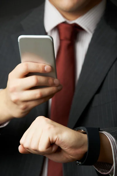 Hombre de negocios Sincronización de reloj inteligente con teléfono móvil —  Fotos de Stock