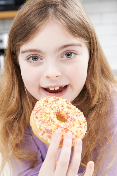 Chica joven comiendo rosquilla azucarada para merienda —  Fotos de Stock