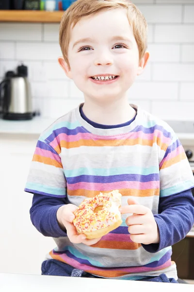 Joven comiendo rosquilla azucarada para merienda —  Fotos de Stock