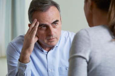 Depressed Mature Man Talking To Counsellor clipart