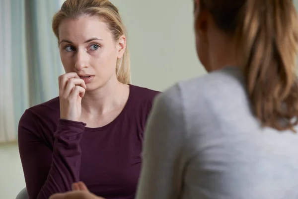 Jovem mulher discutindo problemas com conselheiro — Fotografia de Stock